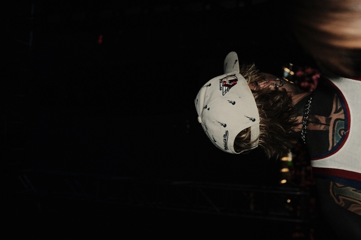Figure with Mitchell and Ness hat on dark stage