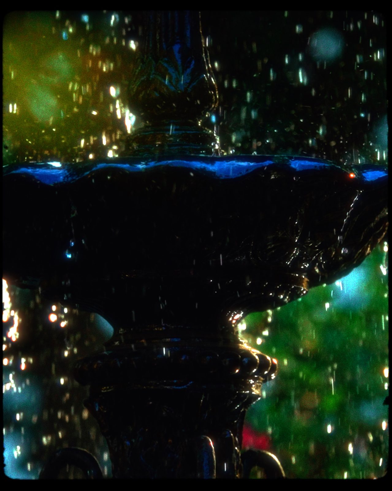 Fountain with water droplets and blue green bokeh