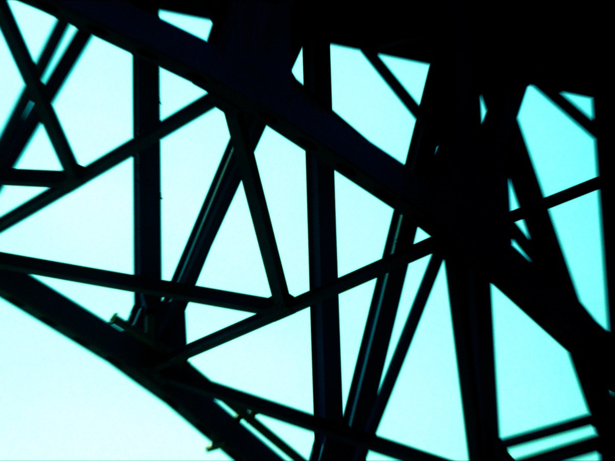 Steel structure silhouette against teal sky