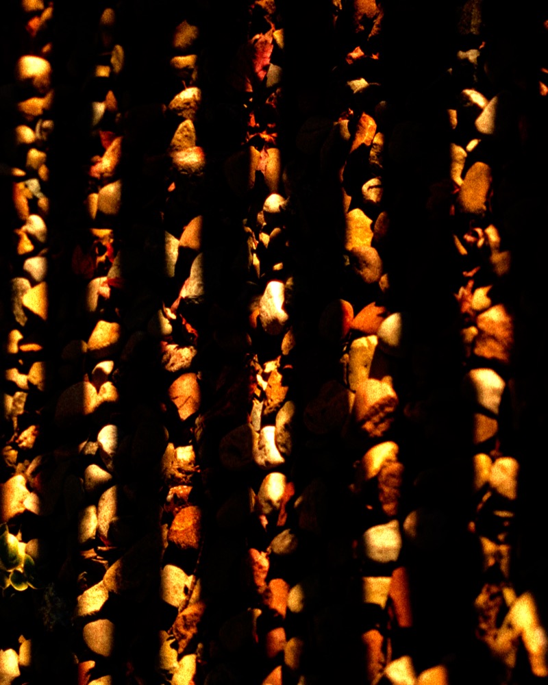 Stones lit through vertical bars in golden light