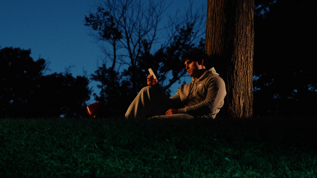 Person reading by tree at night