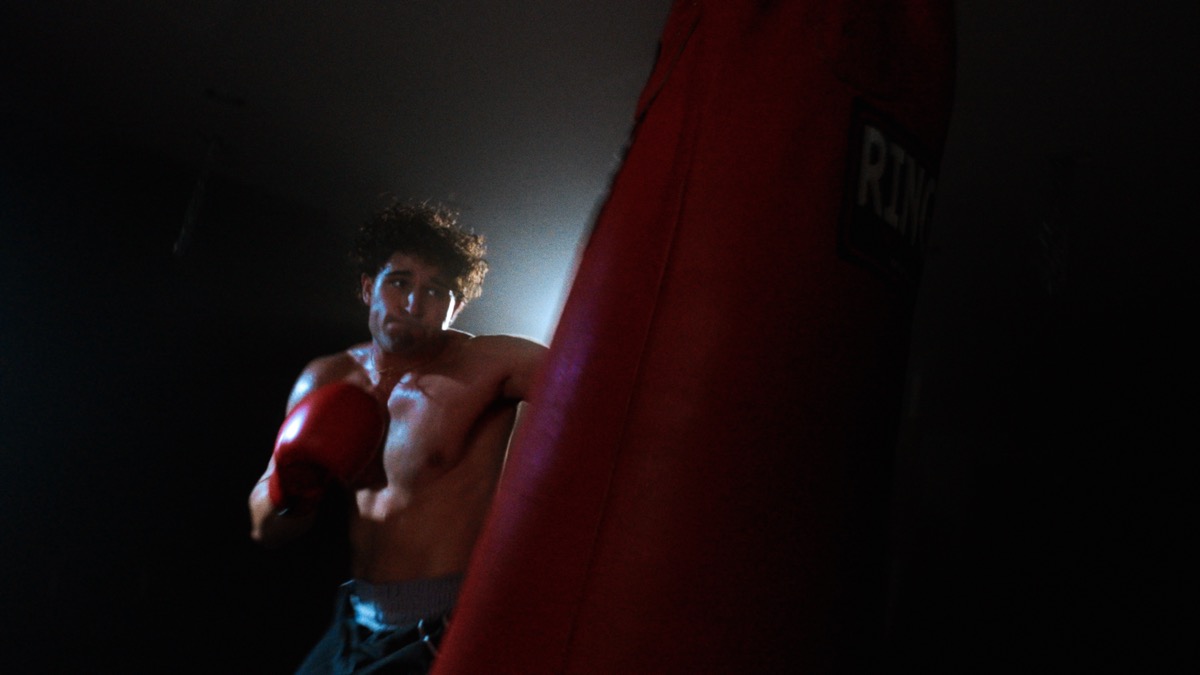Boxer with heavy bag in dramatic light