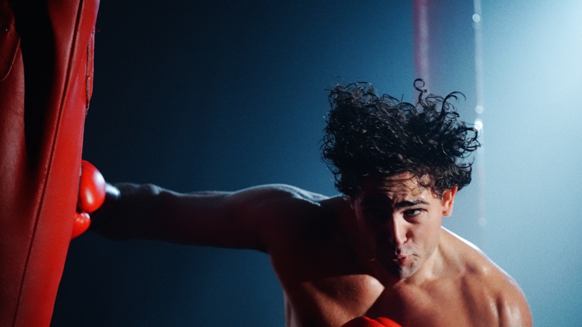 Boxer throwing punch in blue and red light